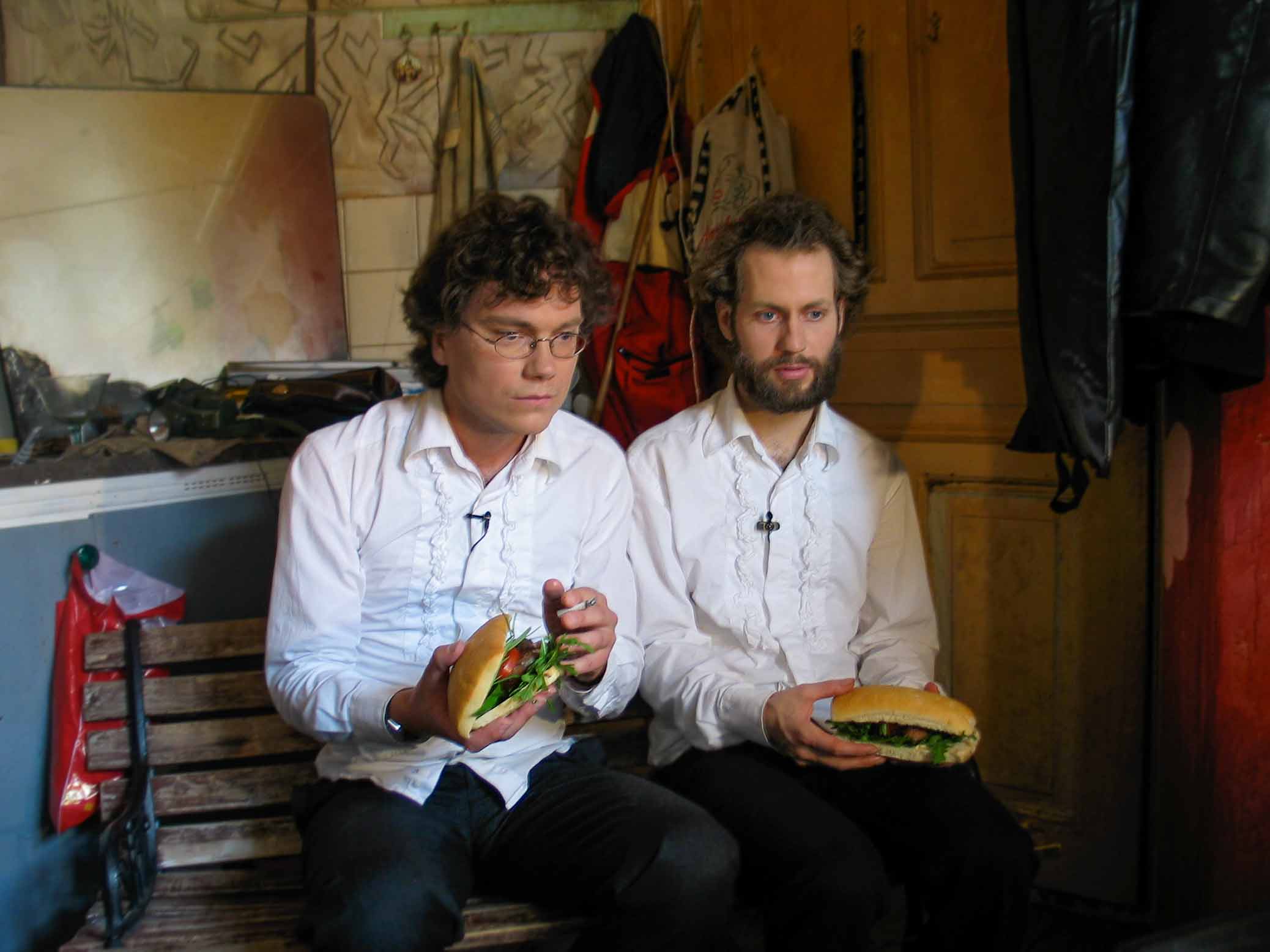 Cuisine Bizarre, video still, Frans Einarsson and Björn Perborg with sandwiches and cigarette.